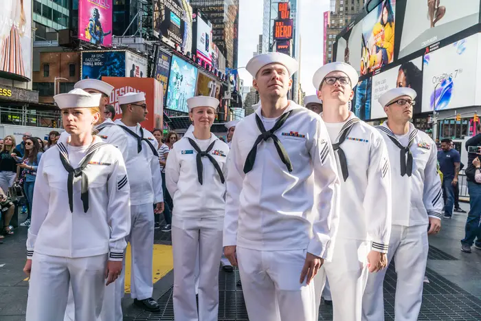 A group of men and women in U.S. Navy uniforms on a New York City street